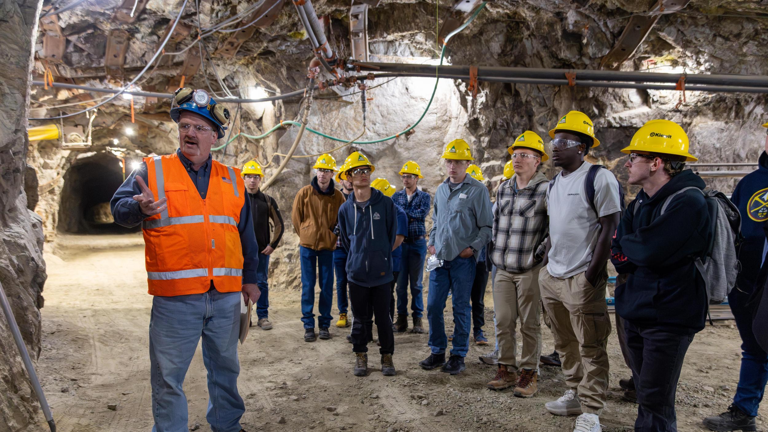 A mining engineering teacher speaks to a group of Mines students in a tunnel inside Edgar Experimental Mine.