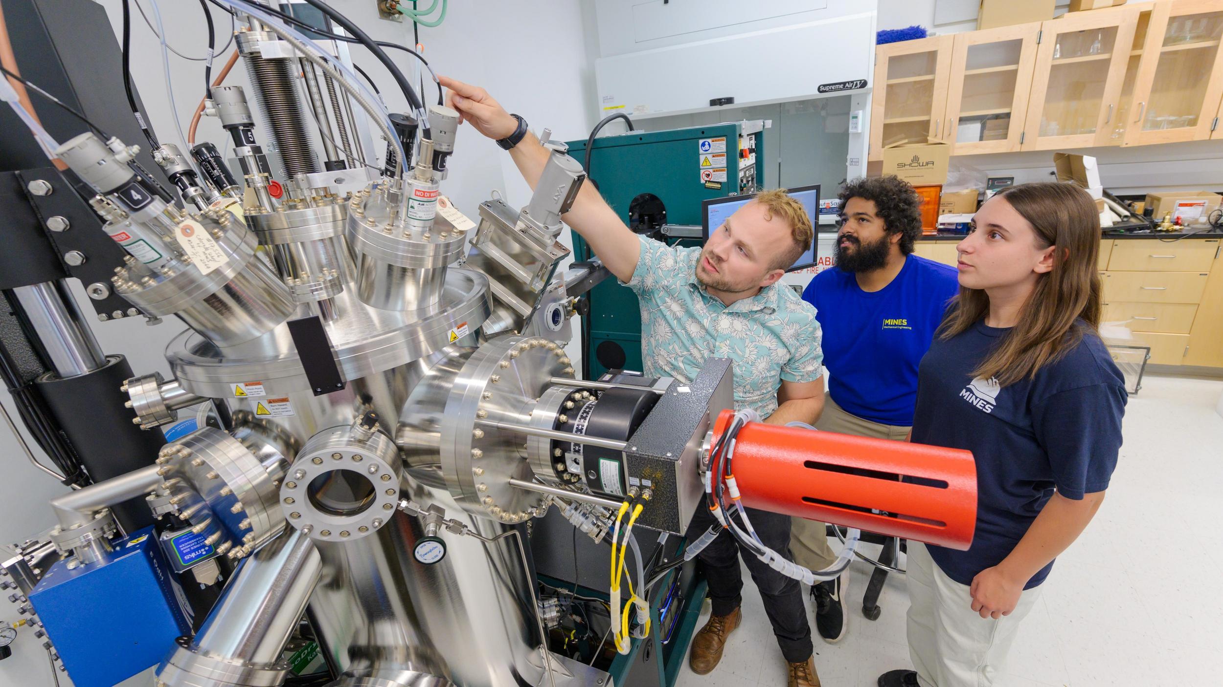 A group of people standing around a machine in a lab.