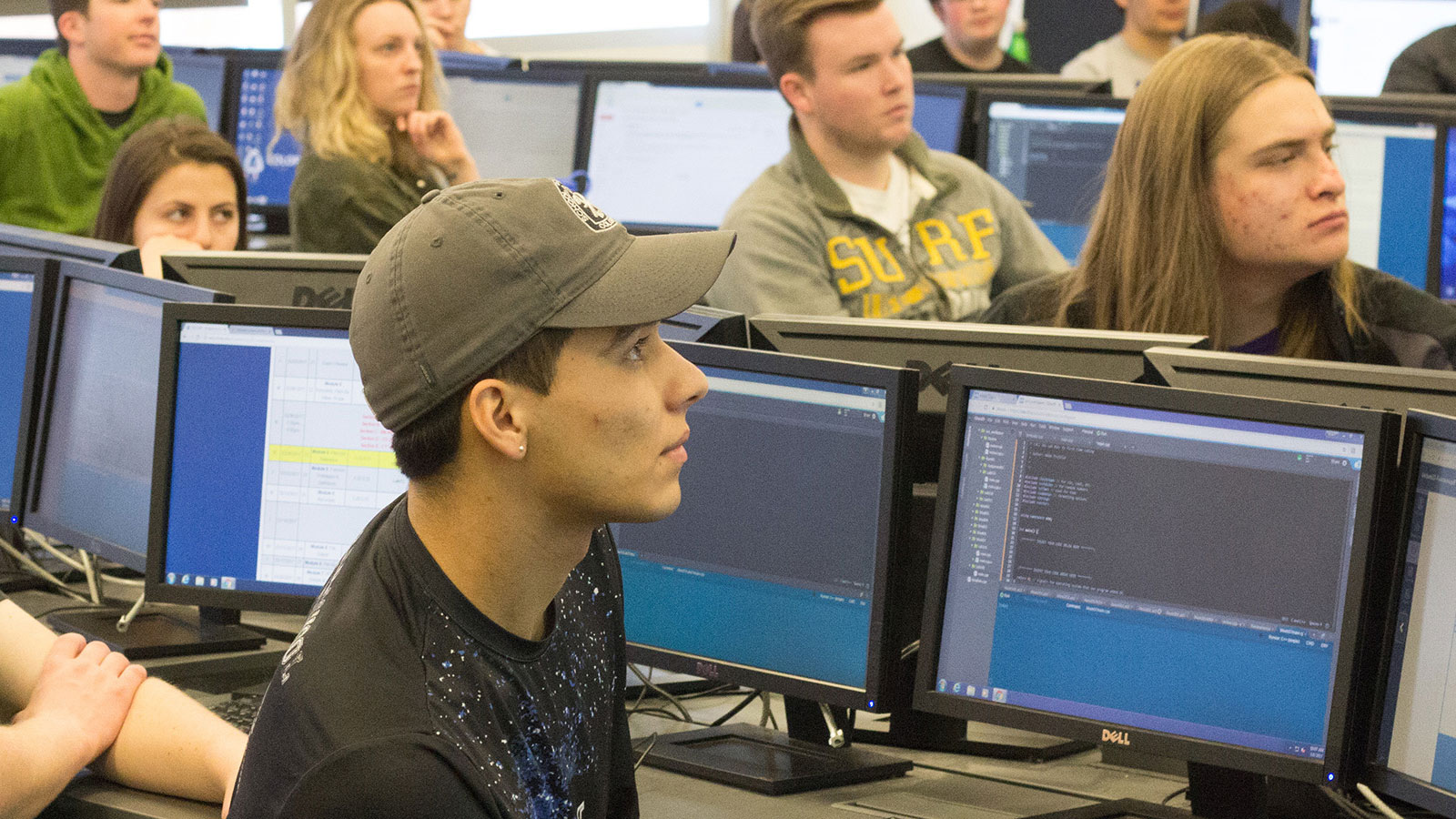 A group of people sitting at computers in a computer lab.