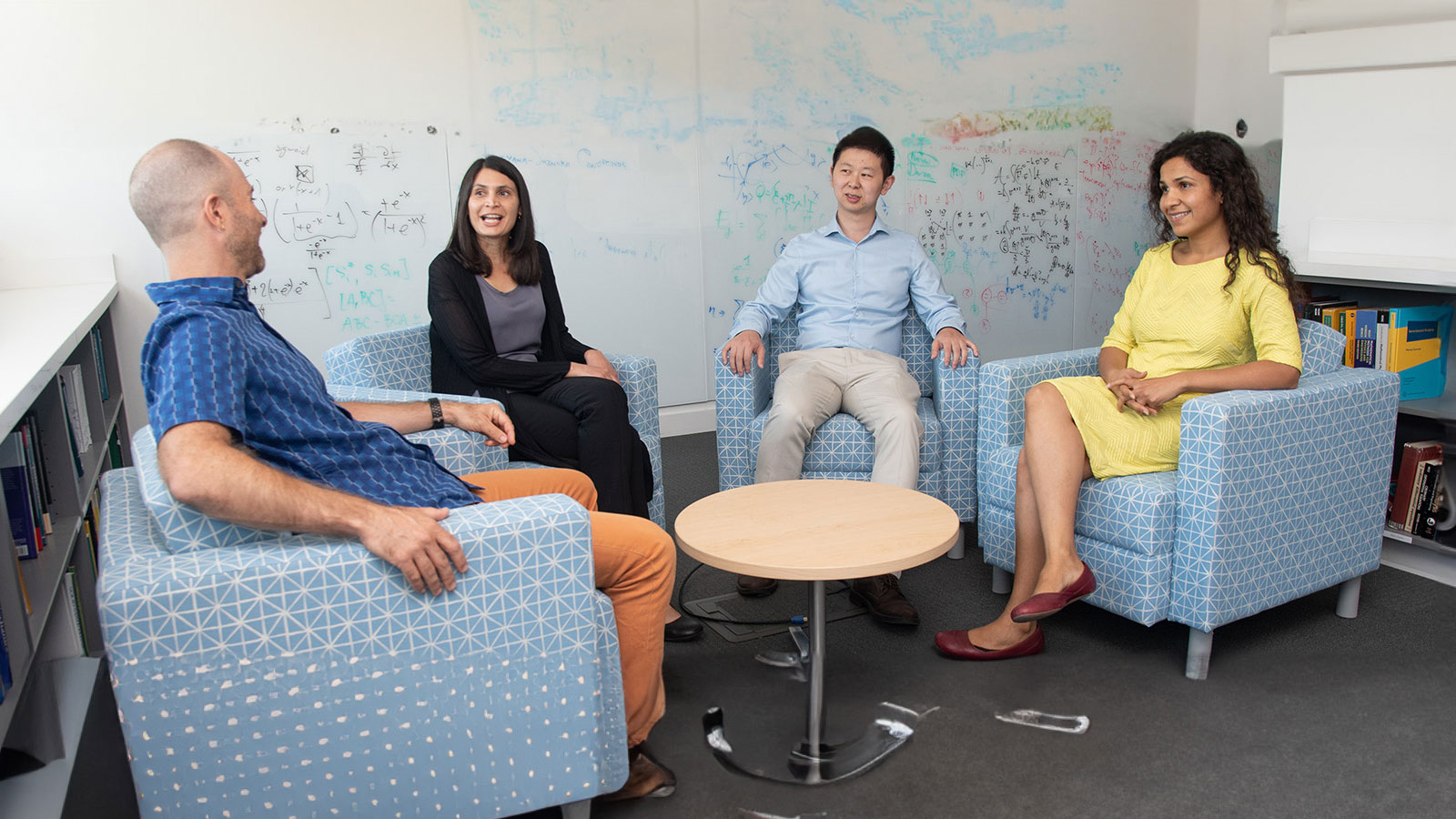 A group of people sitting around a table in a room.